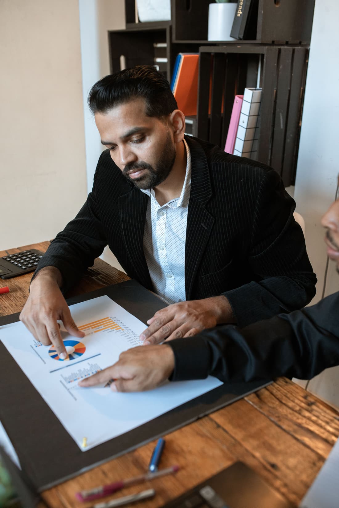 Dirigeant en rendez-vous, analysant des graphiques de performance de son entreprise avec un conseiller